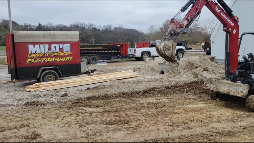 Milo's trailer and mini excavator prepping a site for concrete